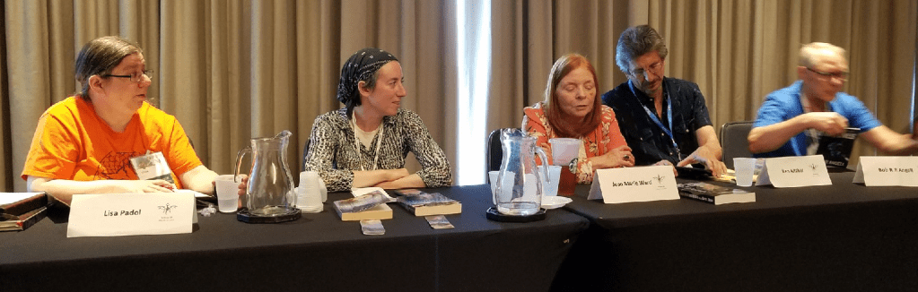 Image of all the panelists sitting in a row at a table.