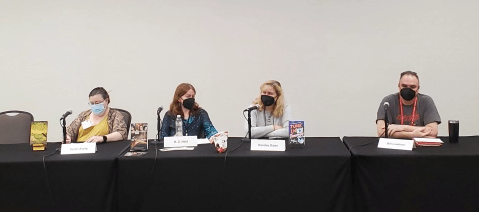 The panelists, left to right: Sarah Avery, R.Z. Held, Randee Dawn, and Bill Lawhorn. Sitting at a table with nose/mouth masks on.